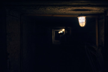 Long underground brick tunnel angle shot. old lantern in the foreground.