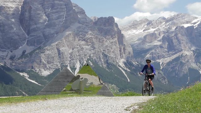 Active young woman riding her mountain bike in the Dolomites area, Italy