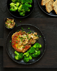 Fried pork steak with broccoli and onion sauce.
