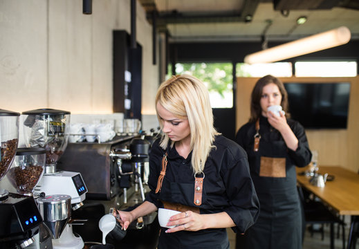 Female barista making espresso coffee.