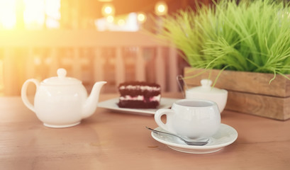 Kettle with a drink and dessert in a street cafe. Tea in the ket