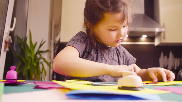 Crane shot. Scrapbooking. Little girl glueing and cutting colored paper. Children's creativity, handicraft