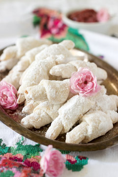 Traditional Romanian or Moldavian shortcake cookies with jam stuffing and a cup of tea on the light background.