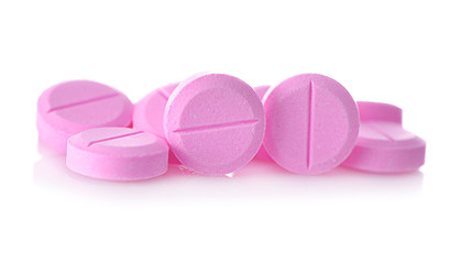 Pink tablet pills isolated on white background.