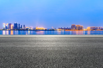 Urban asphalt road and modern buildings with river in Hangzhou at night