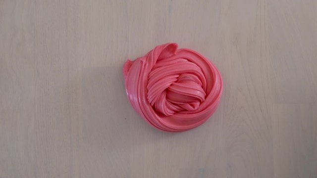 Hands playing with fluffy red slime
