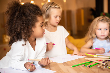 multicultural kids drawing together in kindergarten