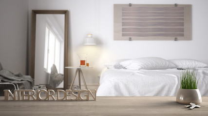 Wooden table, desk or shelf with potted grass plant, house keys and 3D letters making the words interior design, over blurred modern bedroom, project concept copy space background