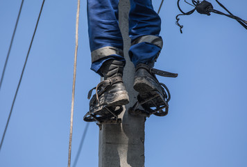 electrician worker on a pole with wires, electricity repair works
