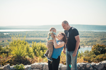 Happy family with baby son on nature background