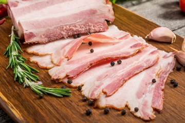 Slices of bacon on the wooden background