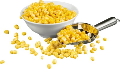 Sweet yellow corn in white bowl with spoon isolated on white
