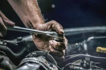 Fototapeta Auto mechanic working on car engine in mechanics garage. Repair service. authentic close-up shot obraz