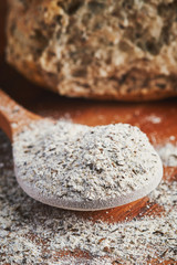 Organic buckwheat flour in wooden spoon on table