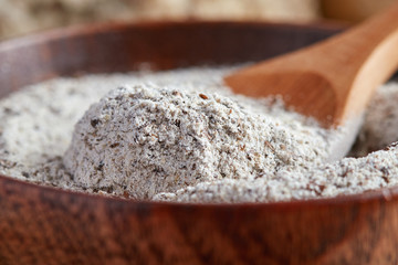Organic buckwheat flour in wooden bowl on table