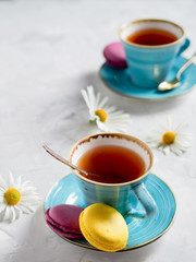 Two cups of tea with macaroons.