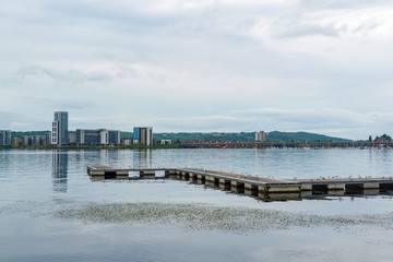 A jetty at Cardiff Bay and buildings on opposite bank seen in calm evening - 1
