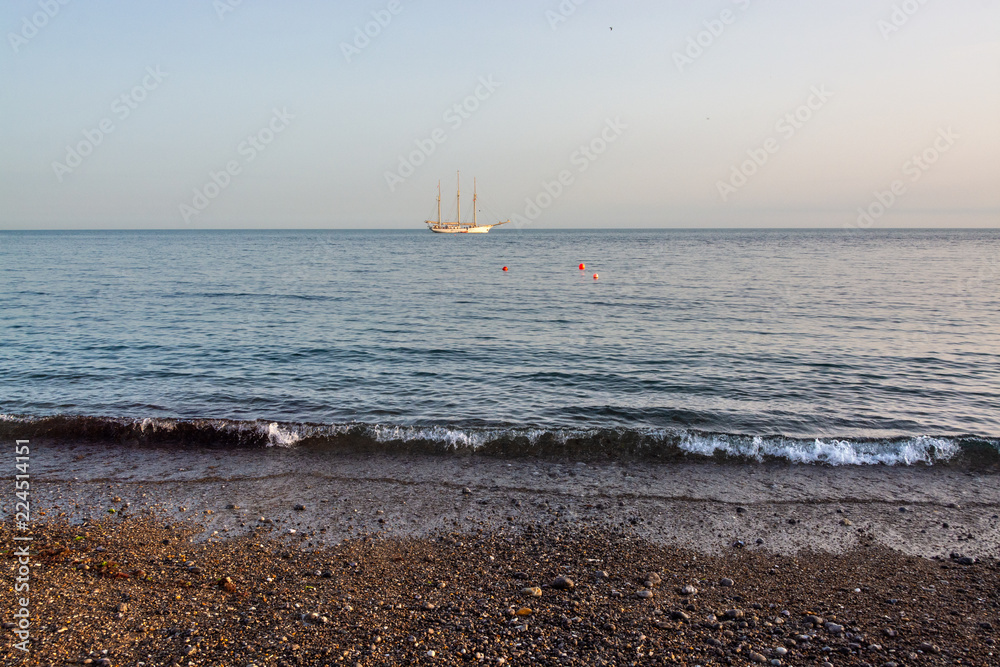 Wall mural gentle waves of ocean approaching the shore in calm evening in uk summer