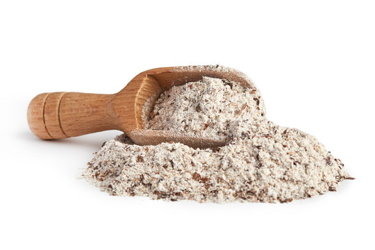 Pile of buckwheat flour with wooden scoop isolated on white background