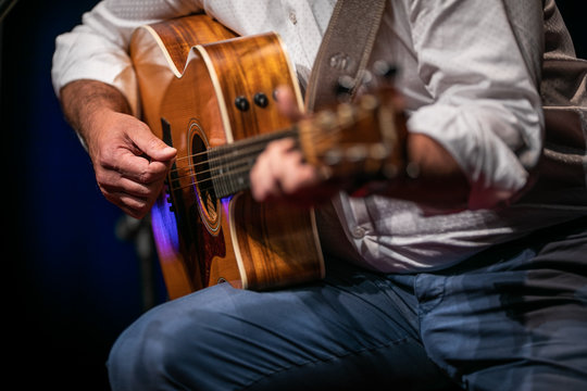 Man playing a guitar on stage (shallow DOF; color toned image)