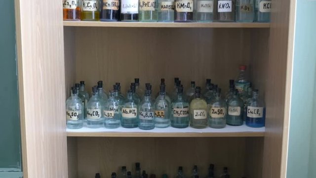 Old chemical Cabinet. Cabinet with vintage bottles filled with liquid chemical elements
