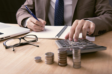 business accountant with calculator writeing note financial on office table. concept planning budget and audit.