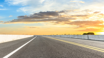 Clean asphalt highway and beautiful sky clouds at sunset
