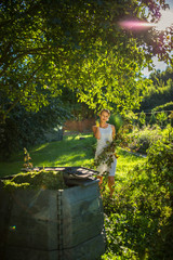 Pretty, young woman gardening in her garden, cutting branches, preparing the orchard for the winter