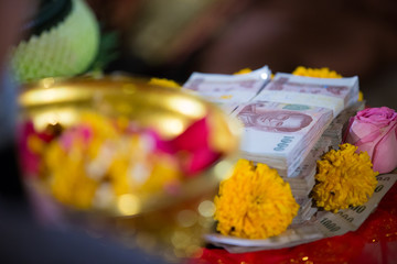 Close up Thailand banknote surrounded aroma petal as rose, jasmine,marigold. a part of bride price in thai wedding ceremony,