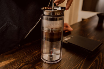 Making coffee in the American press. Hot drink. Welding coffee with the help of pressure and wetting the grain in the filter. Hot glass kettle with boiling water. Coffee house.