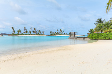 Amazing island in the Maldives ,Beautiful turquoise waters and white sandy beach with  blue sky  background for holiday vacation .