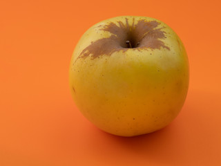 Apple on orange background. Selective focus with shallow depth of field.