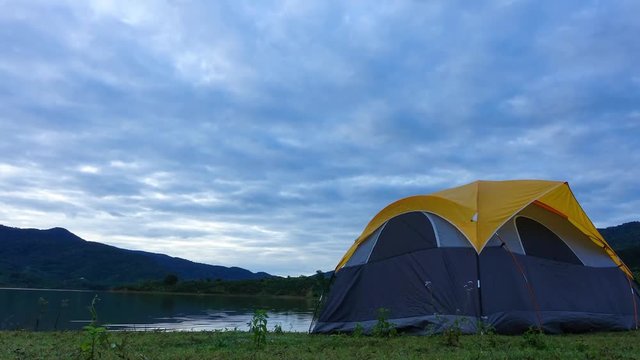 Video timelapse of camping in sunset and sunrise. Royalty high-quality free stock timelapse footage of camp on lake and mountain landscape, under amazing sunset sky and cloud. Tent camping in natural