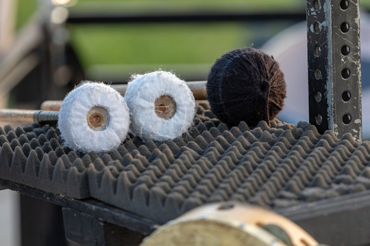 three large mallets waiting to be used by a sideline percussionist