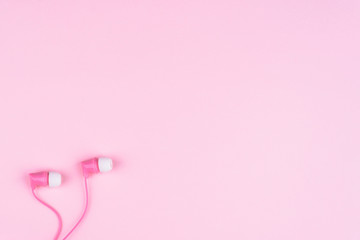 background with free space: pink headphones on light pink backgr
