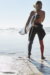 Portugal, Algarve, man on the beach with surfboard
