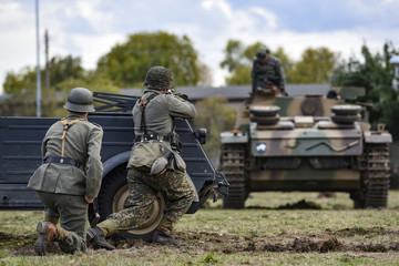 Historical reenactment of soldiers attacking a tank during the Second World War.
