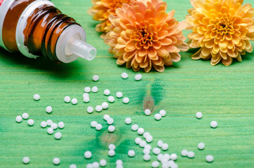 Obraz na płótnie Canvas homeopathic globules on a green wooden background