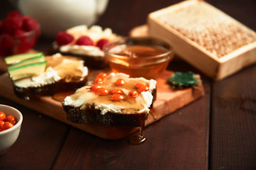 Healthy breakfast. Crispbread, raspberries and honey on the table, wooden background. Honey flows down to the table