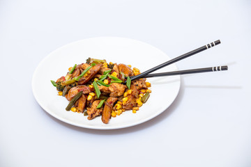 Wok food on a white ceramic plate is tasty and fresh with sauce on a light isolated background