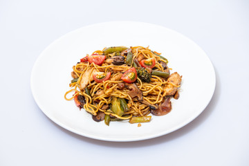 Wok food on a white ceramic plate is tasty and fresh with sauce on a light isolated background