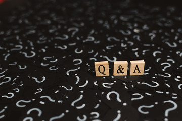 wooden alphabet tiles with Q&A letter on black paper with QUESTION MARK. Concept of Question and...