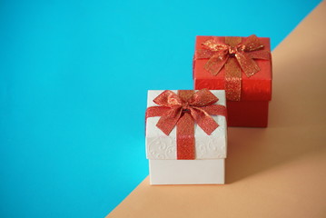 Red and white gift boxes on blur and brown background, picture have space for idea.
