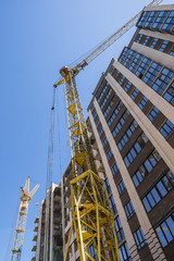 Fototapeta na wymiar Construction of a high-rise building with a crane. Building construction using formwork. Cranes and buildings against the blue sky.