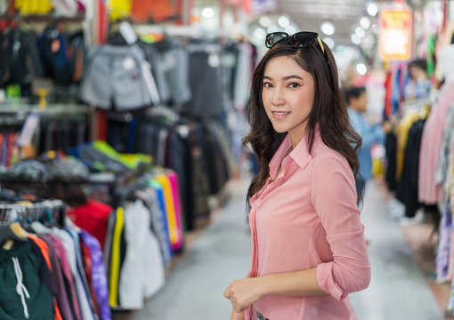 woman choosing and buying clothes in shopping store