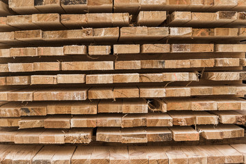 Piles of wooden boards in the sawmill, planking. Warehouse for sawing boards on a sawmill outdoors....