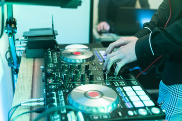 DJ plays and mix music on digital mixer controller. Close-up DJ performance controller, digital...