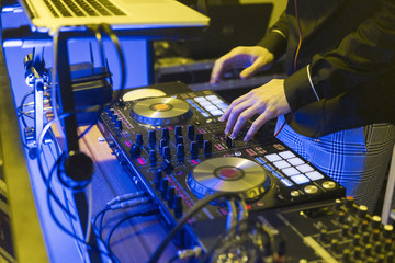 DJ plays and mix music on digital mixer controller. Close-up DJ performance controller, digital midi turntable system, adjustable torque, aluminum-turntable platter, fader, knob and slider, button.