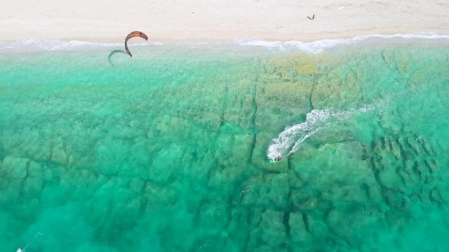 Aerial - Top view of young man kiting on a sunny day in summer season