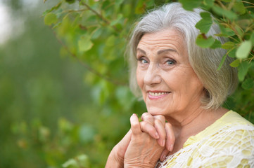 Portrait of smiling elderly woman posing outdoors